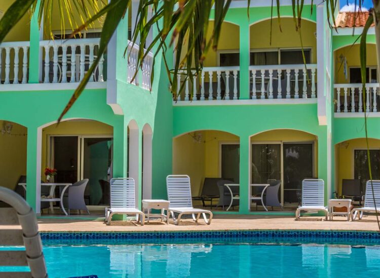 Outdoor pool area with green and yellow building in the background