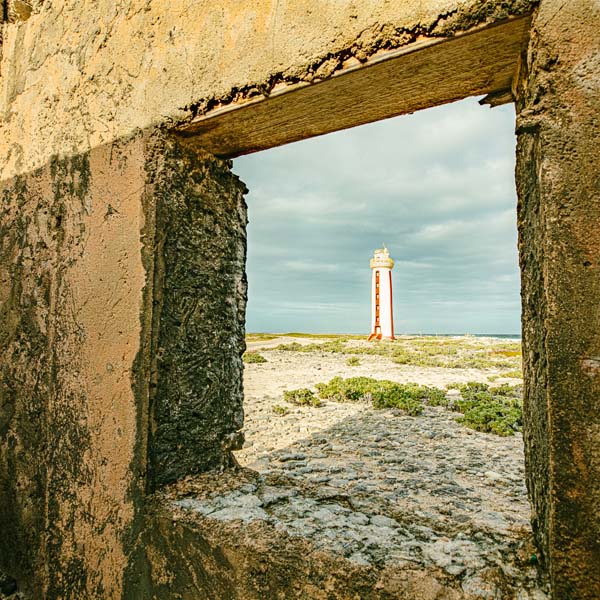 View of beach lighthouse through building window