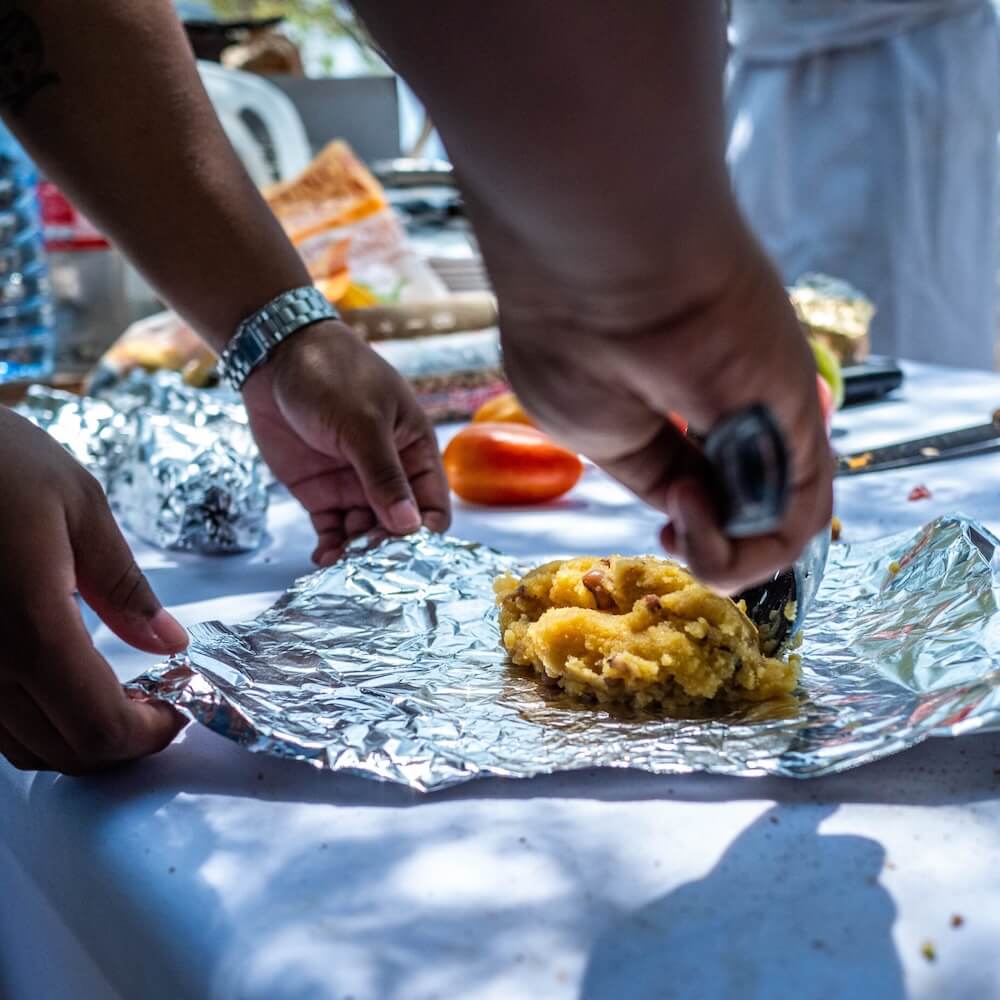 Hand cutting food on tin foil