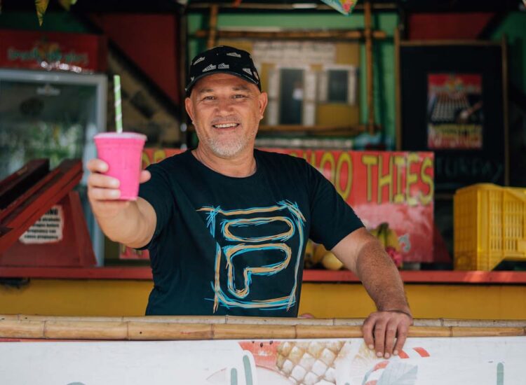 Man holding smoothie and smiling at camera