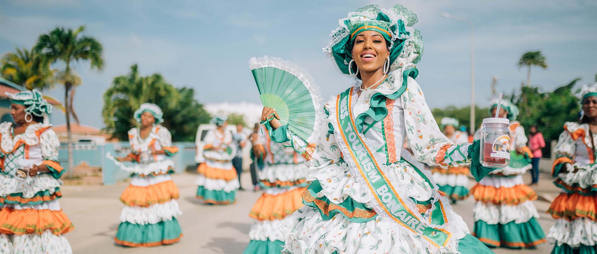 Women in celebration dresses dancing and smiling at camera
