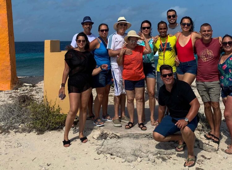 Multiple people posing by the ocean